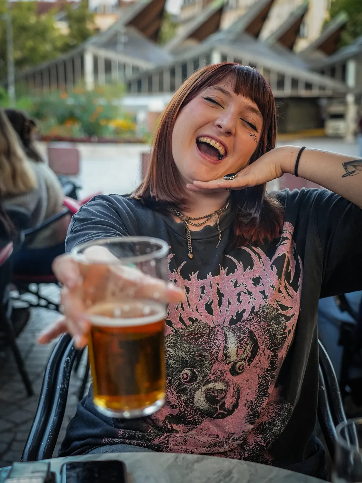Une cliente lève sa bière en terrasse